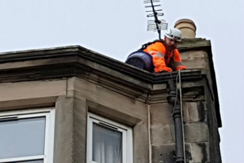 Man fixing roof with safety rope Midlothian